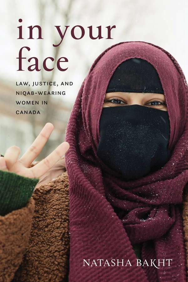 Book cover for In Your Face: Law, Justice, and Niqab-Wearing Women in Canada by Natasha Bakht. The cover shows a woman wearing a niqab face covering. Her eyes are smiling and her fingers are forming a peace sign.